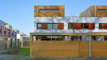 Foto der Reihenhausanlage in Kranichstein. Zu sehen sind mehrere Gebäude aus Holz.