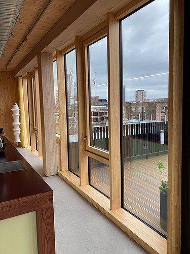 Photo of an interior of the Black and White office in London. You can see a timber mullion and transom façade.