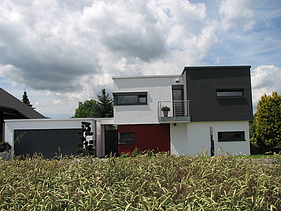 Foto eines kubischen Wohnhauses aus Holz mit Putzfassade. LENO-BSP.