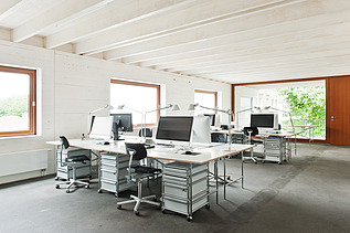 Photo of a furnished office space with visible, white ribbed wooden ceiling. Wooden extension.
