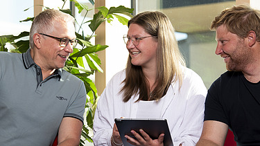 Foto von mehreren jungen Menschen, die sich besprechen. Ausbildung Industriekauffrau:man.