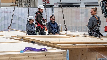 Photo of carpenter colleagues on the timber construction site.