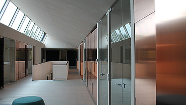 Foto der Anwaltskanzlei FGS Augsburg. Moderner Innenraum mit schräger Holzdecke.