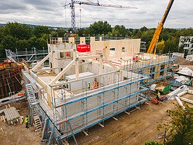 Foto der Montage der Universität Witten-Herdecke. Man sieht LENO-Brettsperrholzelemente die gerade montiert werden.