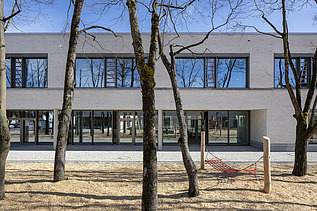 Exterior view of the Vinzenz Pallotti School in Friedberg. You can see a large, white building with a flat roof.