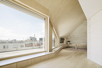 Aufstockungen, Bauen im Bestand. Projekt Aufstockung Rottmannstraße München Foto eines modernen Innenraumes mit großer Fensterfront und Holzoberflächen