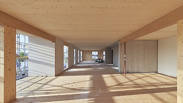 Interior shot of a wooden building room in its shell state. You can see many wooden surfaces.