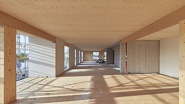 Interior shot of a wooden building room in its shell state. You can see many wooden surfaces.