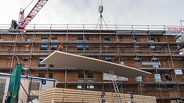 Photo of the Collegium Academicum in Heidelberg during assembly. You can see the unloading of large wooden elements.