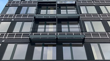 Foto eines mehrgeschossigen Gebäudes mit schwarzer Fassade.