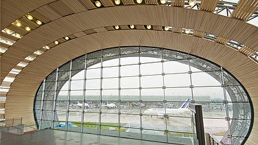 Photo of the Charles de Gaulle Paris airport terminal from the inside. Curved wooden construction.