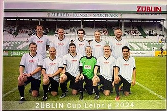 Gruppenfoto von der ZÜBLIN-Timber-Fußballmannschaft in weißen Trikots. Die Torwärterin trägt grün.