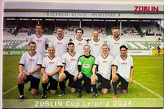 Group photo of the ZÜBLIN-Timber soccer team in white jerseys. The goalkeeper wears green.