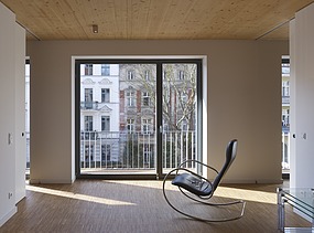 Foto eines Innenraumes mit Holzdecke. Es steht ein Schaukelstuhl darin.