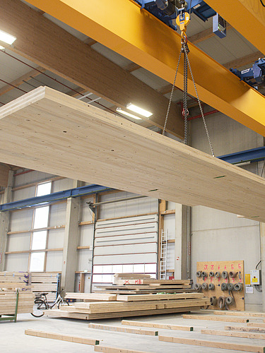 Foto eines LENO-Brettsperrholzelements am Kran in der Produktionshalle von ZÜBLIN Timber.