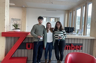 Photo of three young people smiling at the camera.
