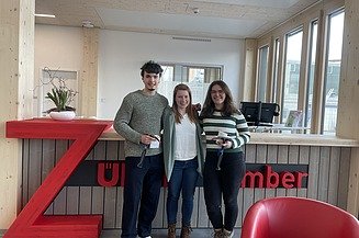 Photo of three young people smiling at the camera.