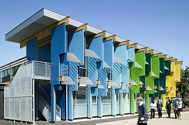Foto eines Schulgebäudes mit bunten Fassadenelementen aus Furnierschichtholz.