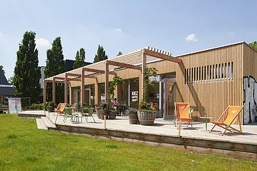 Allet Pank Pavillon Berlin Foto eines Holzgebäudes mit Flachdach und Terrasse.