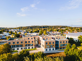 Photo of Witten University from the outside. You can see a large wooden building.