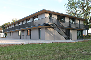 Foto der Anwaltskanzlei FGS Augsburg. Modernes Holzgebäude mit Flachdach.