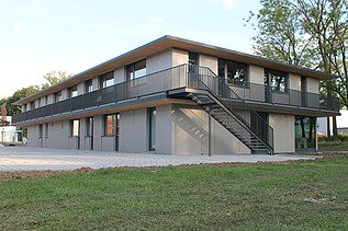 Foto der Anwaltskanzlei FGS Augsburg. Modernes Holzgebäude mit Flachdach.