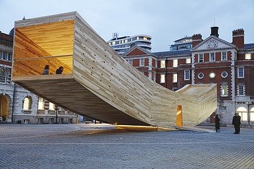 The Smile - Sculpture Design Festival London Photo of the curved wooden sculpture The Smile in London. The wooden box can be walked on and is intended to represent a smiling mouth.
