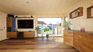 Foto eines Wohnhauses aus LENO-Brettsperrholz. Wohnzimmer mit vielen Holzoberflächen.