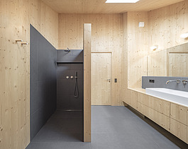 Photo of a modern wooden house with wooden facade. Interior photo of bathroom. LENO wooden walls.