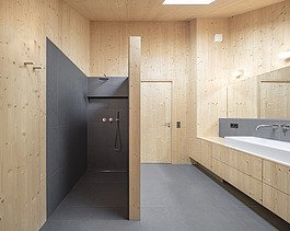 Photo of a modern wooden house with wooden facade. Interior photo of bathroom. LENO wooden walls.