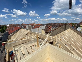 Foto einer Aufstockung aus Holz. Man sieht einen Dachstuhl aus Holz.