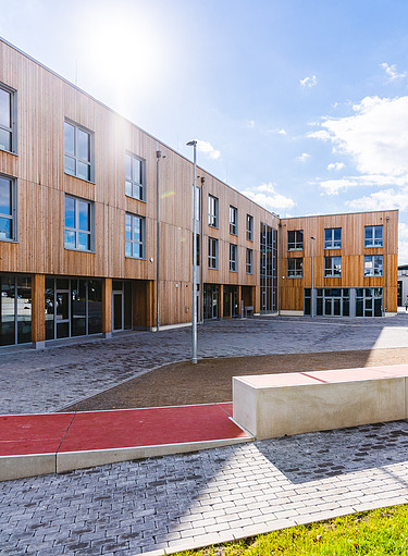 Fotos eines großen Holzgebäudes mit Holzfassade und Flachdach