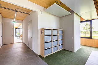 Photo of an office space. You can see a locker and wooden ceiling.