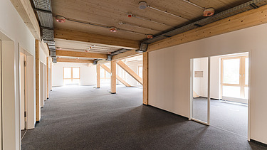 Photo of the inside of Witten University. You can see an interior with light-colored walls and a wooden ceiling