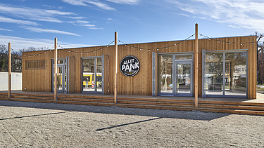 Photo of a wooden building with flat roof and terrace.