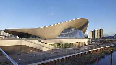 Photo of the Aquatics Center in London from the outside. You can see the wooden roof construction.