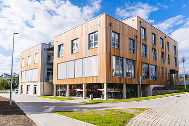 Photo of the exterior of a wooden building with a wooden façade. Witten-Herdecke University.