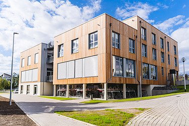 Foto einer Außenaufnahme eines Holzgebäudes mit Holzfassade. Universität Witten-Herdecke.