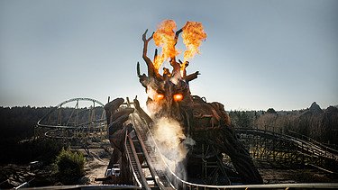 Foto der Holzachterbahn Colossos im Heide Park Resort Soltau. Zu sehen ist feuerspeiender Holzdrache und ein Teil der Achterbahn.