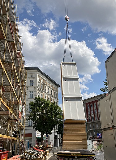 Foto der Holzbaumontage in der Stendaler Straße in Berlin. Man sieht ein großes LENO-ADD-Holzelement am Kran.