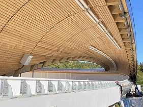 Foto einer Rodelbahn. Man sieht eine Holzüberdachung und nur einen Ausschnitt davon
