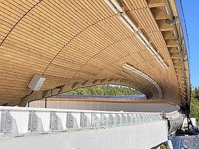 Foto einer Rodelbahn. Man sieht eine Holzüberdachung und nur einen Ausschnitt davon