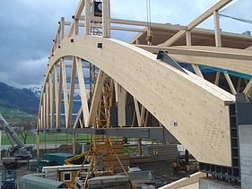 Foto der Montagehalle Pilatus CH-Stans. Zu sehen ist ein großer, gebogener Brettschichtholz-Träger