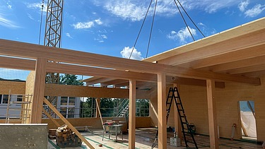 Photo of a timber construction site in Berlin. You can see the assembly of the ribbed elements.