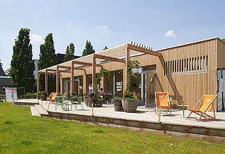 Foto eines Holzgebäudes mit Flachdach und Terrasse.