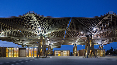 Night shot of the Expo roof in Hanover. You can see large wooden roof constructions 