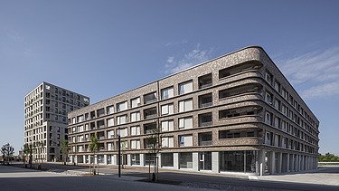 Foto eines großen mehrgeschossigen Gebäudes mit Holzfassade. BUGA-Areal Mannheim.