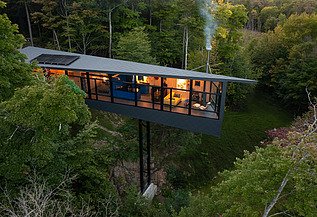 Wohnhaus Vancouver Foto eines Wohnhauses aus Holz auf Stahlpfählen, inmitten des Waldes.