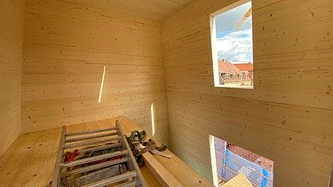 Photo of a building shell made of LENO cross laminated timber. You can see many wooden surfaces in an interior.