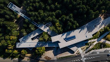 Aerial view of the visitor center in Ruhestein. You can see a building complex in the middle of a forest.
